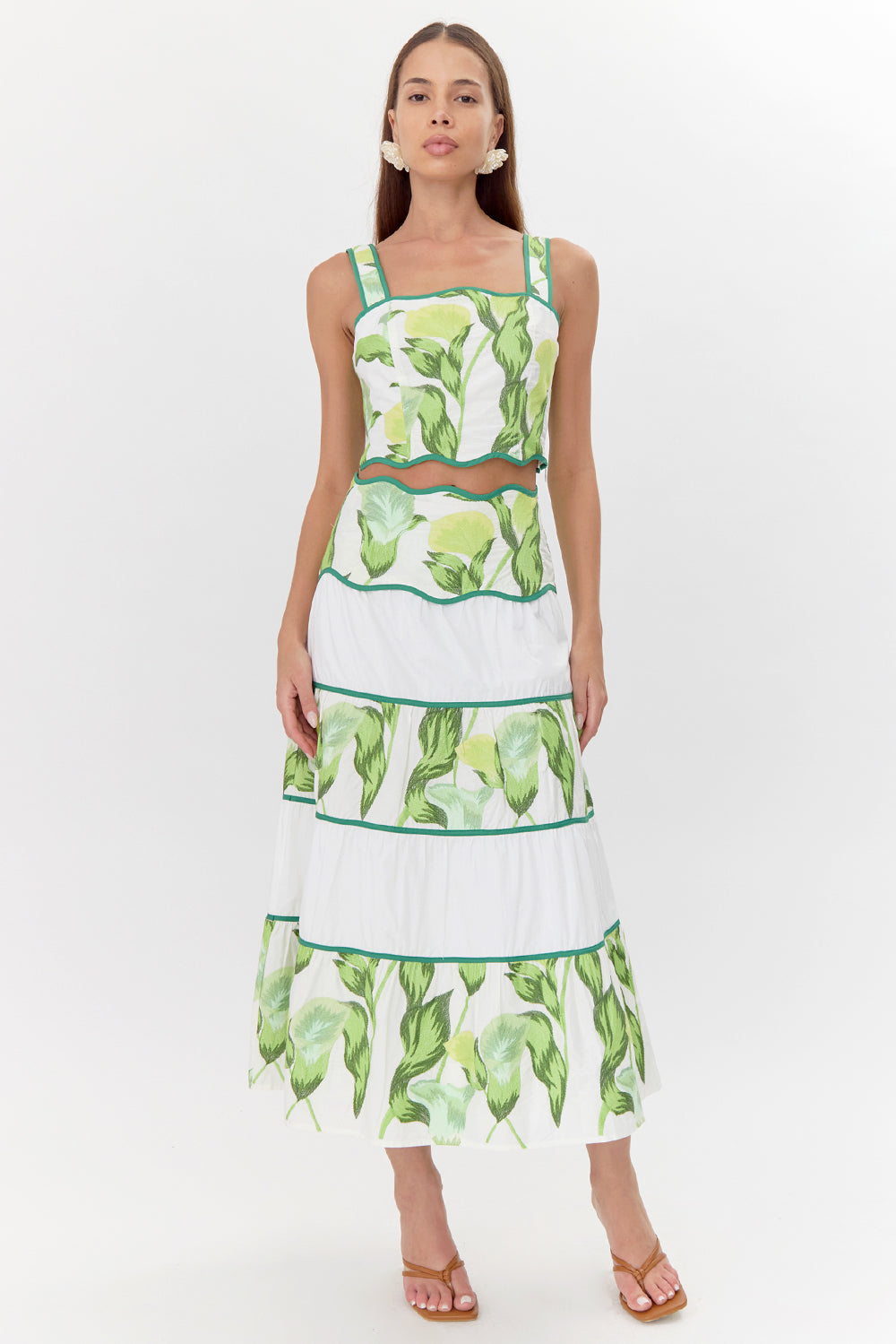 Model wears tiered, floral midi skirt along with a matching crop top.